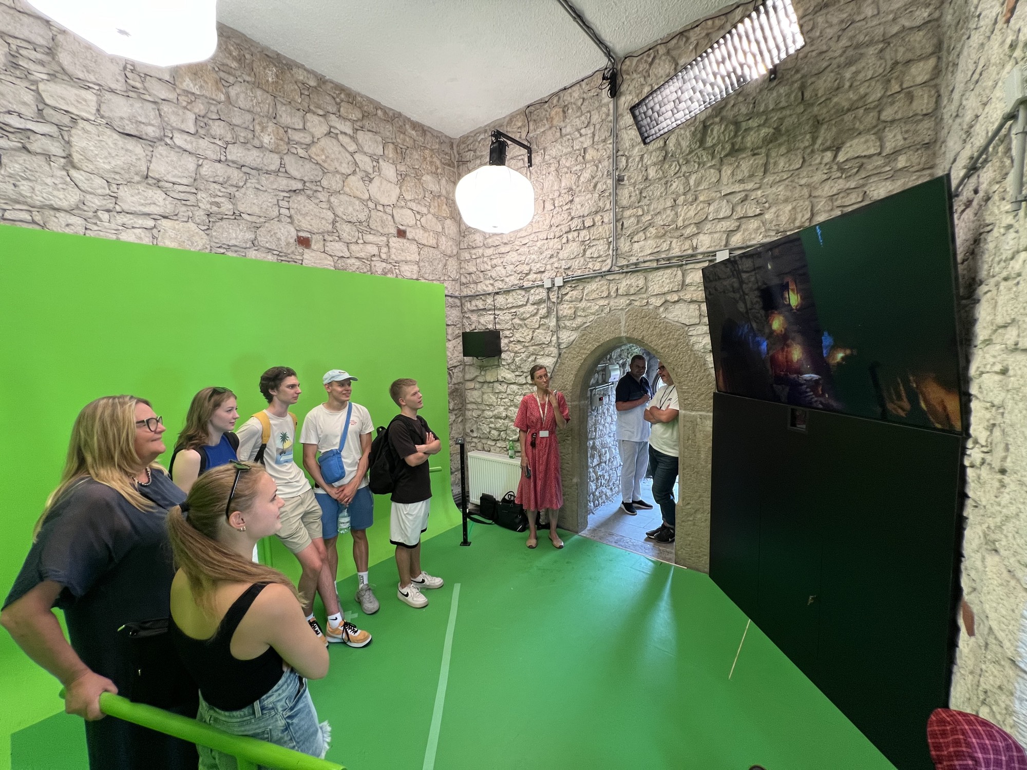 The installation inside the tower: a chroma key room built into the stone interior, with the composited Dragon's Den shown on a screen beside it