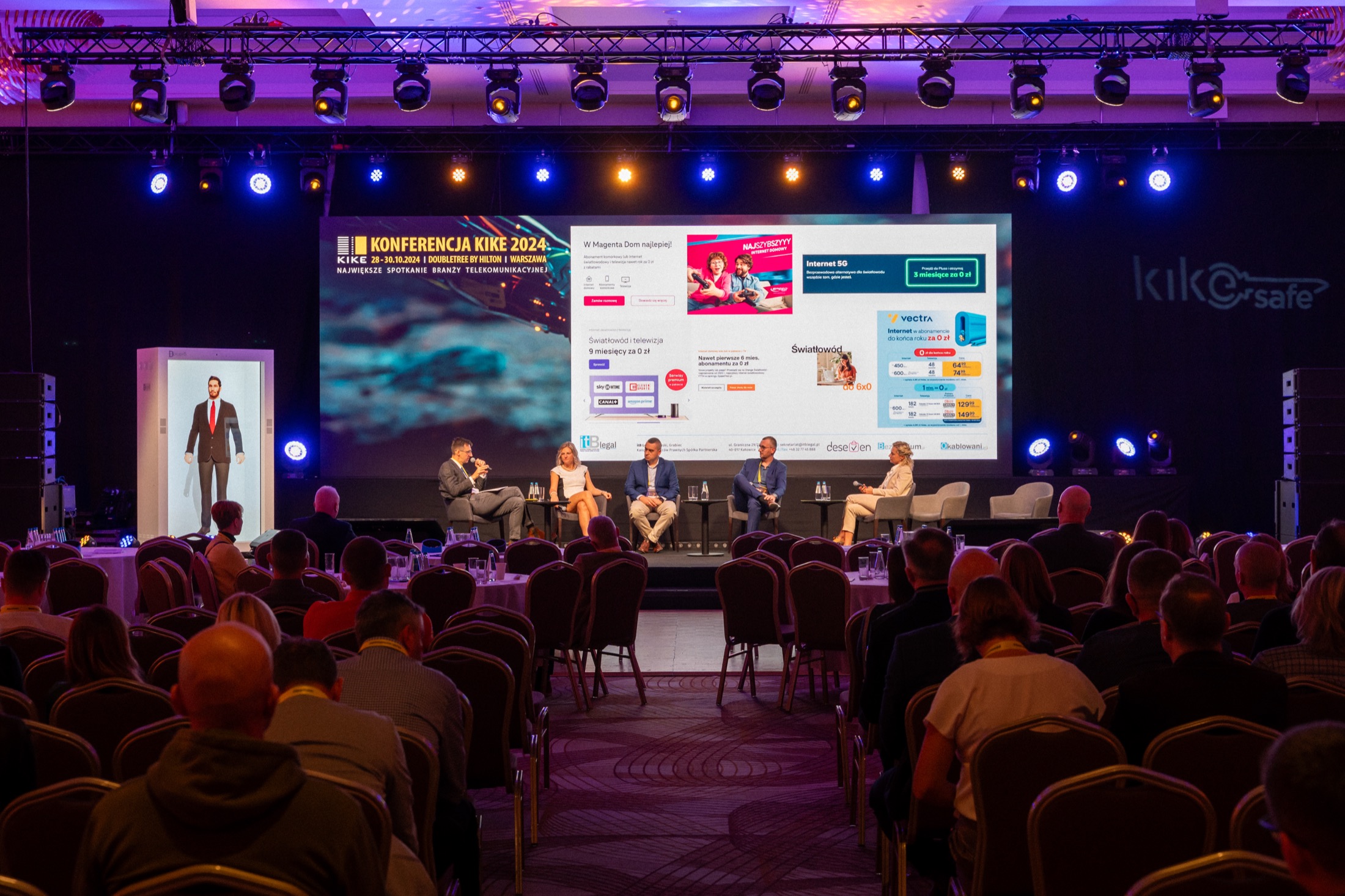 The conference hall: the avatar's cabinet stands to the left of the stage during a panel discussion